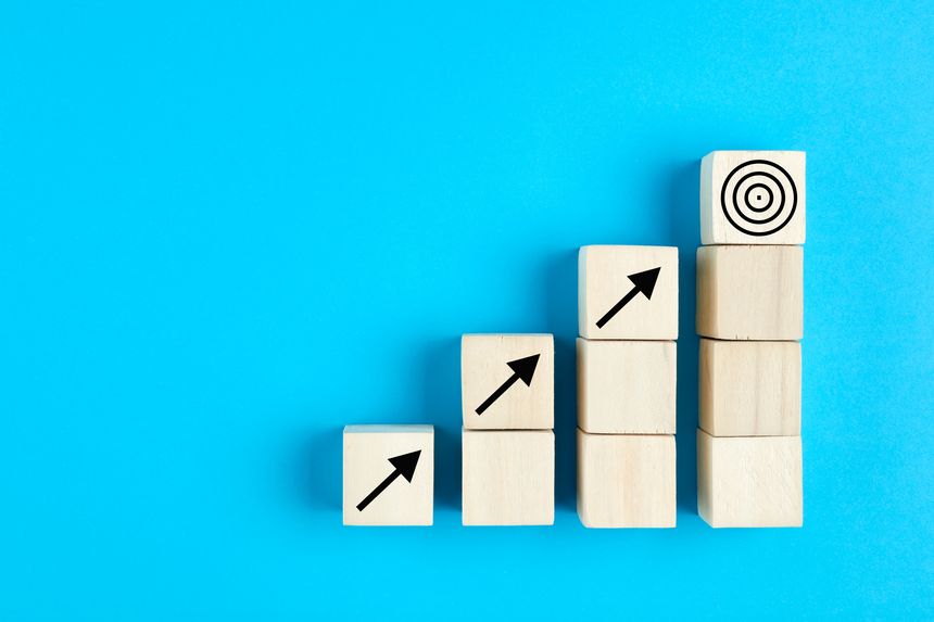 Business or economic growth concept with arrow icons on wooden cubes on blue background