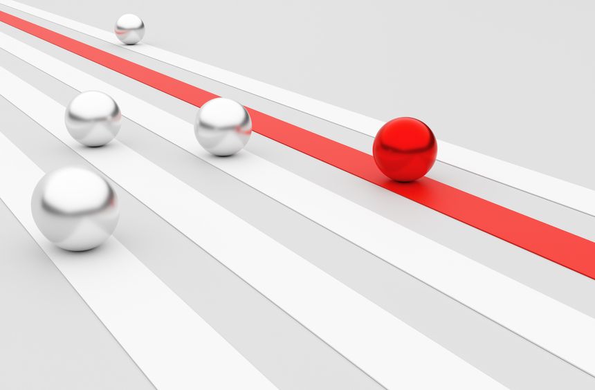 Red ball racing ahead of silver competitors, utilizing a vibrant red fast track to secure victory and showcase unique leadership in competition