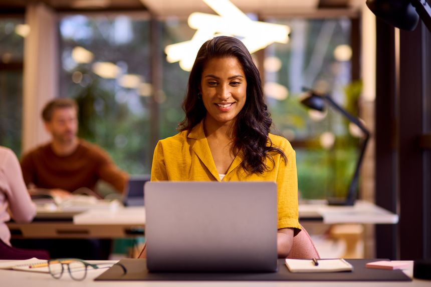 Mature Businesswoman Working On Laptop At Desk In Office