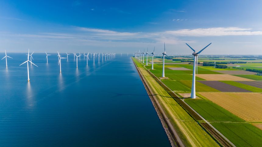 Wind turbines harnessing the power of the breeze create sustainable energy along the scenic Dutch landscape, reflecting a commitment to green technology.