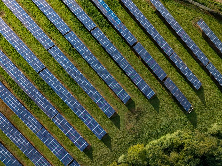 Rows of photovoltaic solar panels on agricultural land generating clean sustainable energy for business and domestic purposes