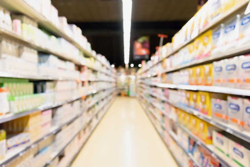 Unscharfer Supermarktgang mit Babymilchprodukten im Regal