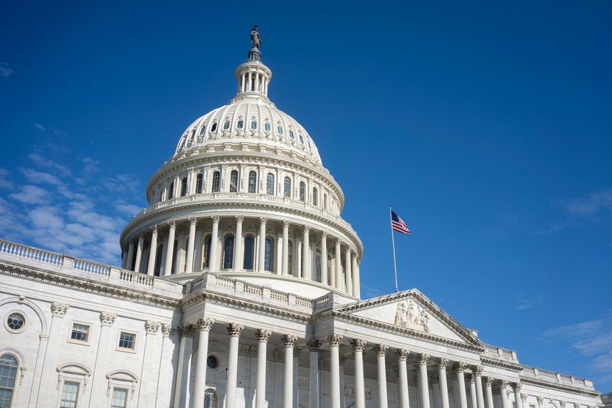 The United States Capitol Building against a clearing blue sky viewed from the east front of the U.S. Capitol building in Washington, DC.