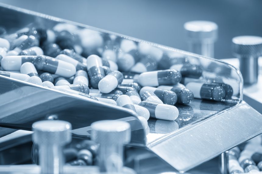 Close up scene the capsules drug mass production process in the light blue scene. Pharmaceutical Manufacturing Tablet.