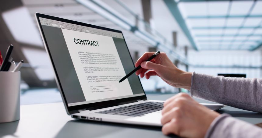 Busy executive insuring trust with legal paperwork on laptop computer.