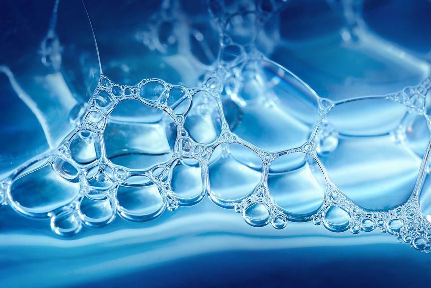 transparent soap bubbles on water creating an abstract pattern
