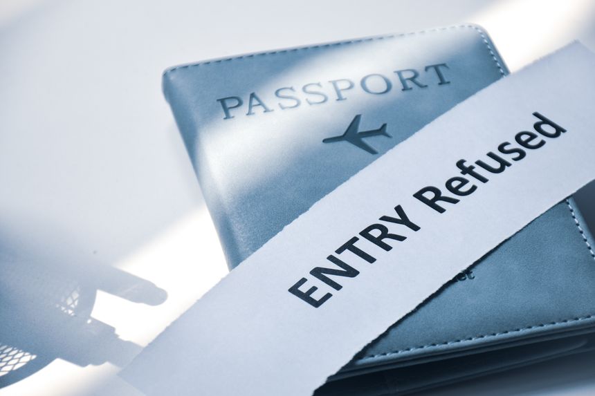 Torn paper with the inscription Entry refused on Passport. Denied entry or entry ban to a country concept, selective focus.