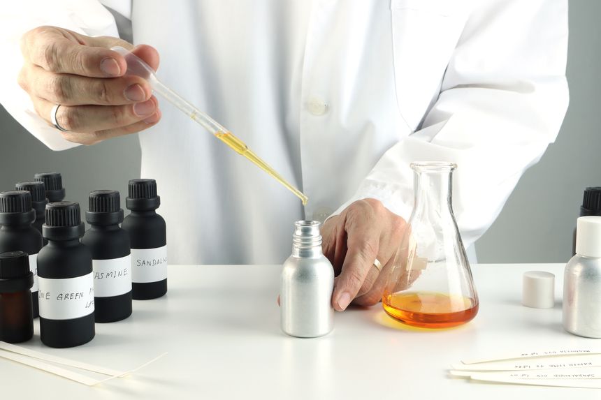 blotter papers in left hand is used in scent testing, essential oil ,fragrance oil bottle for testing smell during blending process for choosing nice scent for scented candles and body perfume in lab testng trying for the best smell scent