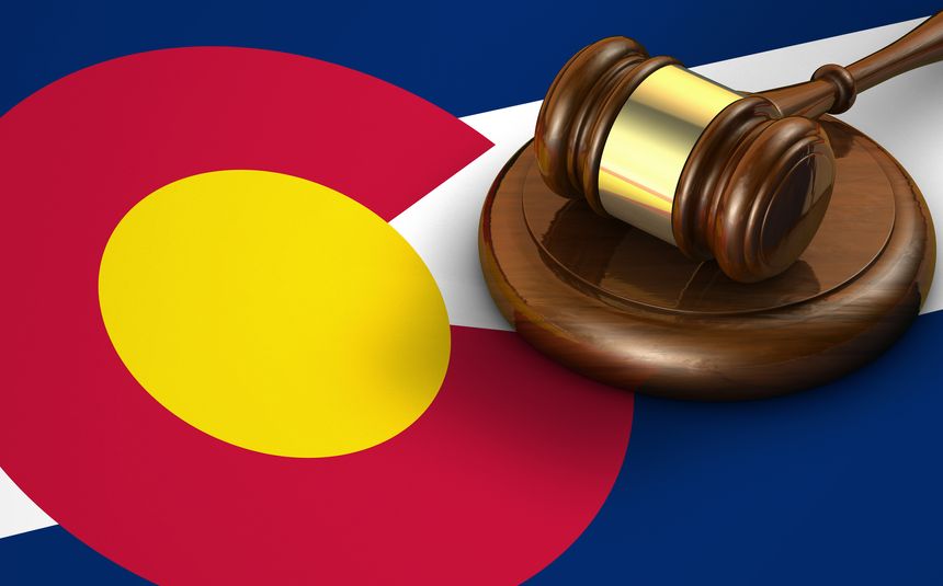 Colorado US state law, code, legal system and justice concept with a 3d render of a gavel on the Coloradoan flag on background.