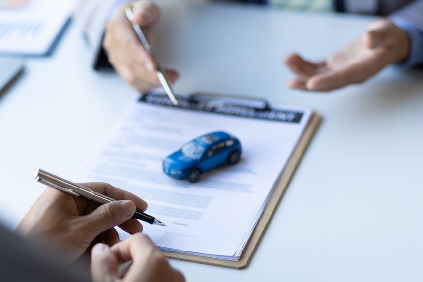 Businessman signing car purchase, lease contract agreement with car salesman, car insurance.