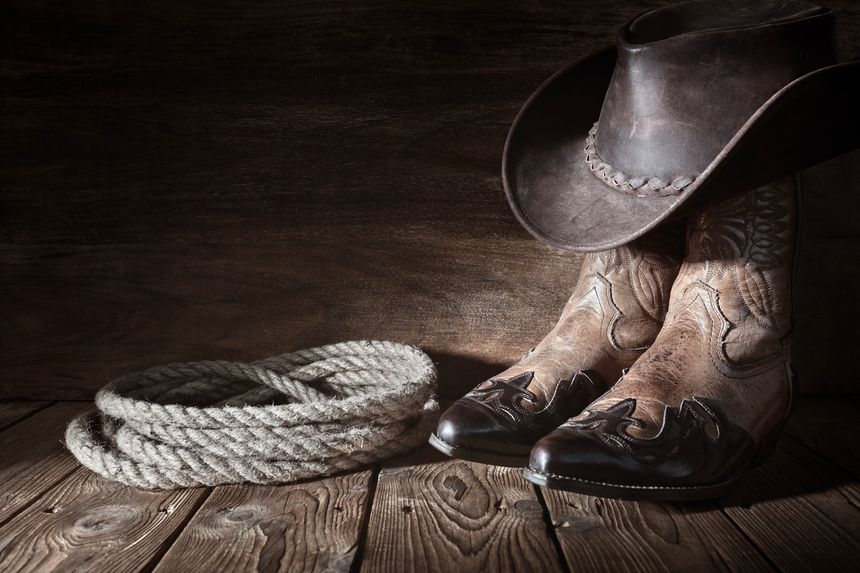 Cowboy boots and hat background with copy space for country music festival, line dancing or wanted advert copy