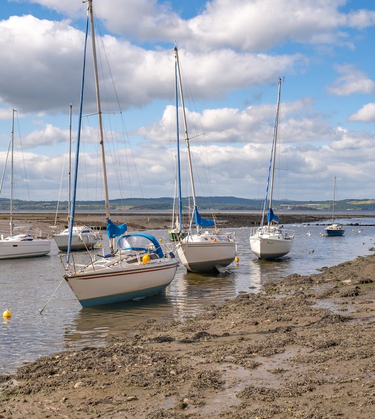 Cramond, Scotland, UK June 19 2022. Sailing boats and leisure boats moored up at the mouth of the Almond River at low tide