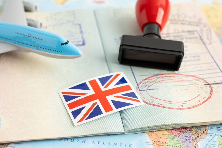 United Kingdom flag with approved Stamp visa and passport document to immigration at airport in country.