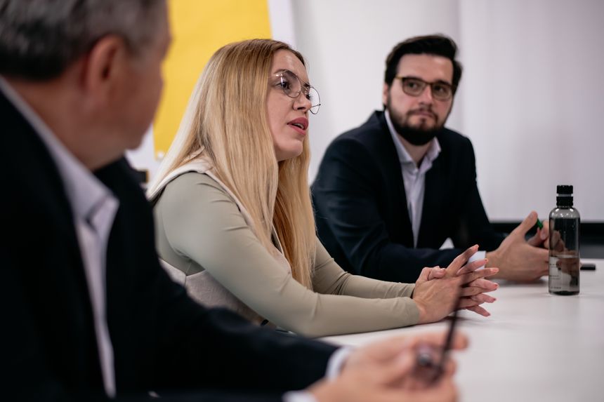 Colleagues participating in a serious meeting, showcasing professional collaboration and strategic thinking in a formal office setting.