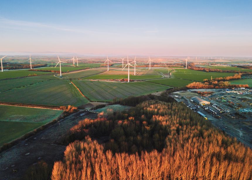 Northumberland UK: 31st Dec 2025: Drone view of Lynemouth Windfarm turbines that produce up to 26 megawatts of green wind power. The turbines stand in golden hour light