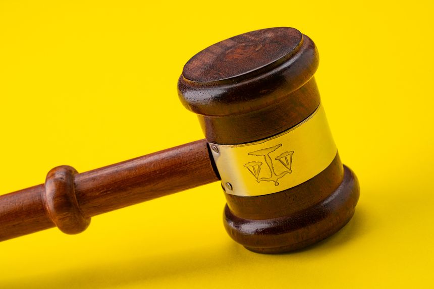 Judge's gavel isolated against a yellow background
