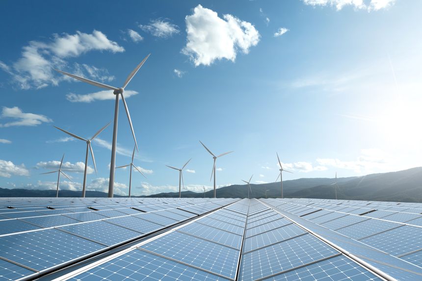 vast solar farm and wind turbine power plant in a mountain landscape. A concept for large scale green energy infrastructure and investment.