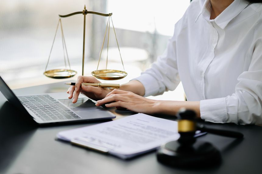 justice and law concept.Male judge in a courtroom  the gavel, working with smart phone and laptop and digital tablet computer on table in morning light