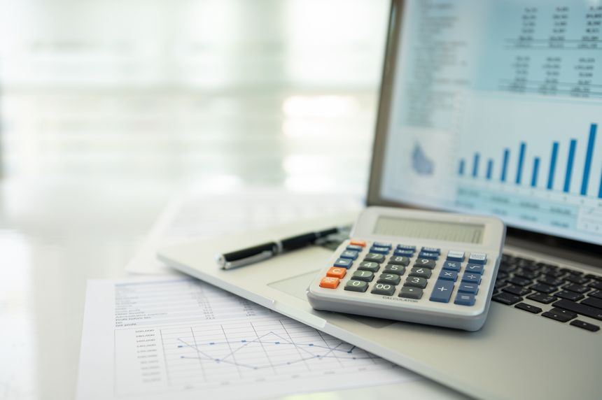 calculator, account statement and business report with financial budget portfolio show on screen laptop computer. accounting business concept.