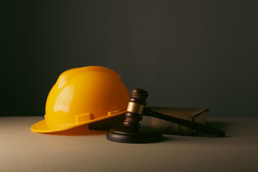 Judge's gavel, book and hard hat on table. Law concept