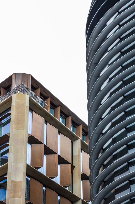 Two modern buildings with contrasting architectural styles in London, featuring prominent design elements, geometric patterns, and a contemporary aesthetic that highlights urban elegance and innovation.