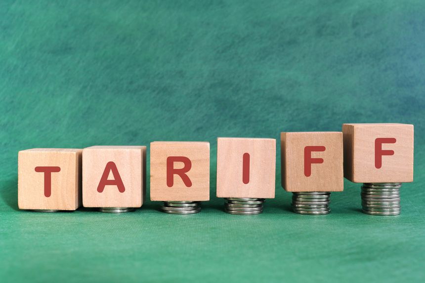 Increase tariff tax concept. Word in wooden blocks with increasing stack of coins.