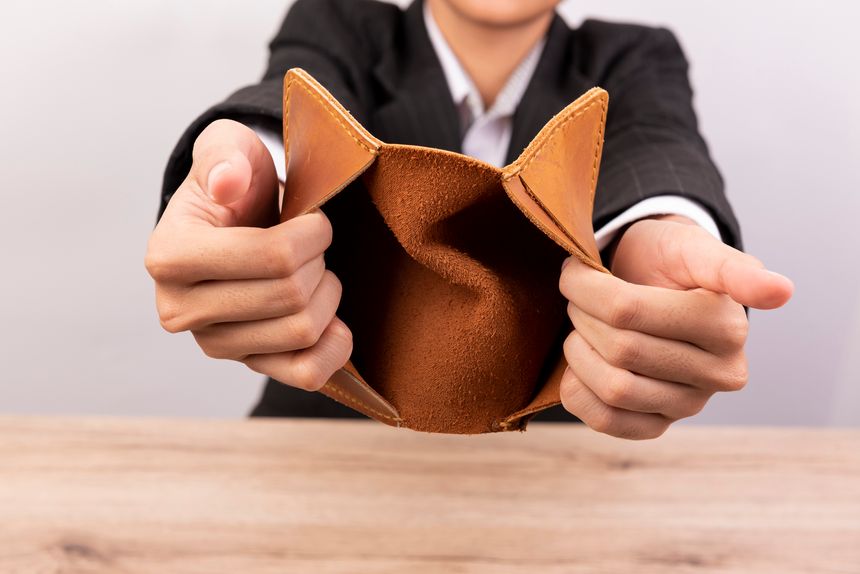 Midsection Of Businesswoman Holding Empty Wallet At Table