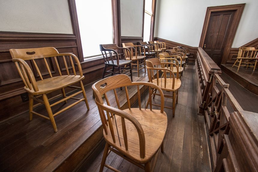 Wooden chairs in a row at an empty jurors box in the USA.