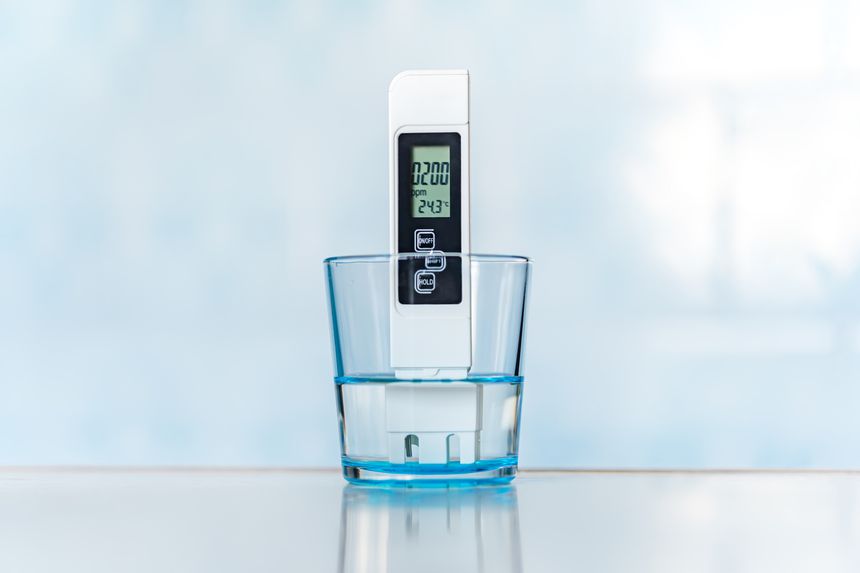 Electronic pH meter in a glass of water. TDS measurement of water. poor water quality, high values of salt impurities,