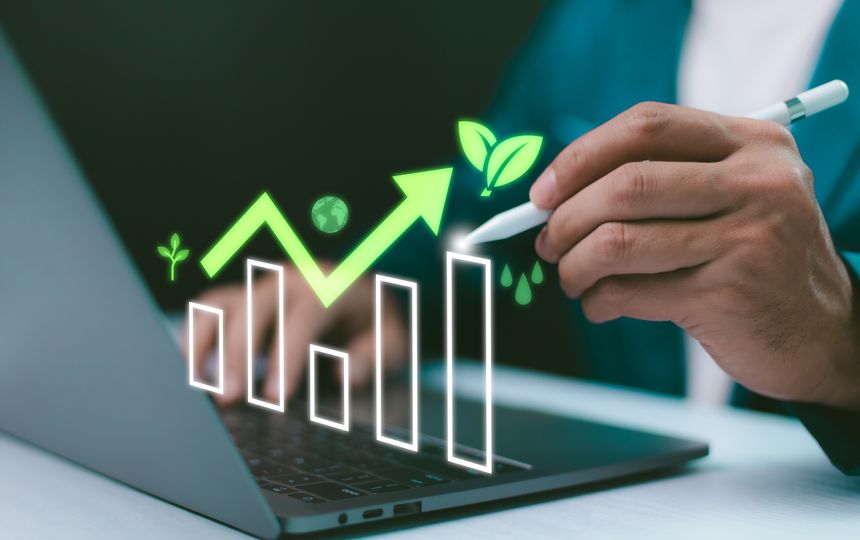 Hand use laptop with digital display a glowing green bar chart, an upward arrow, leaves, a globe, and water drops, sustainable business growth and eco-friendly investment. ESG concept in action.