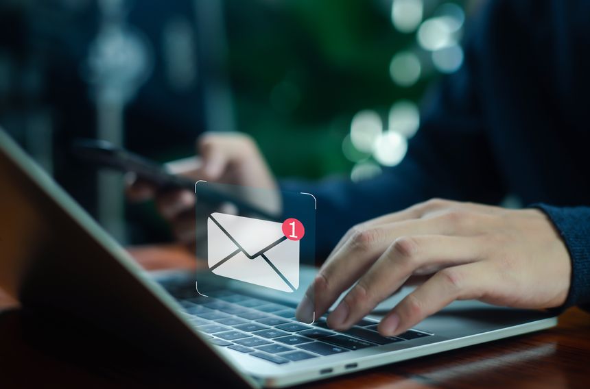 businessman checking email notifications on a smartphone represents digital communication, laptop messaging, and efficient information management in a modern technology-driven workplace.