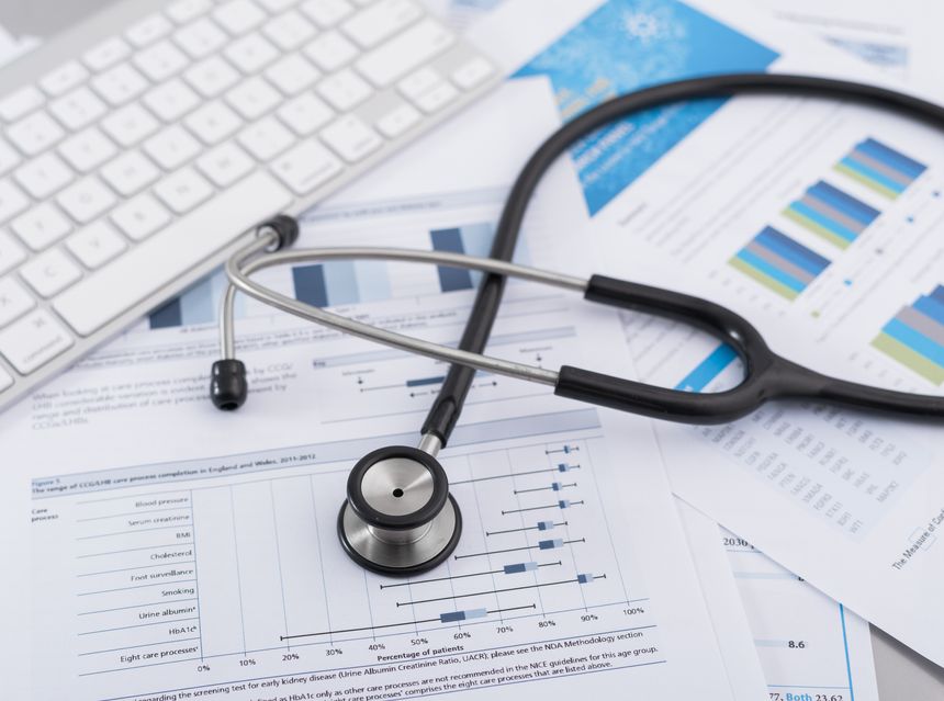 Stethoscope with financial statement on the desk.