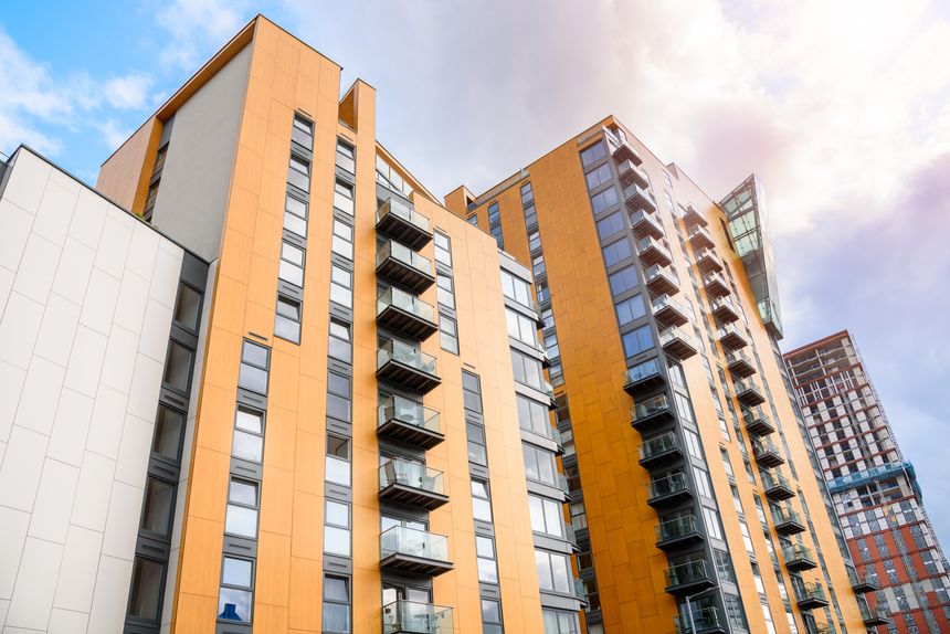 Modern high rise blocks of flats in a city centre under partly cloudy sky in summer. A building under construction is visible in distance. Manchester, England, UK.