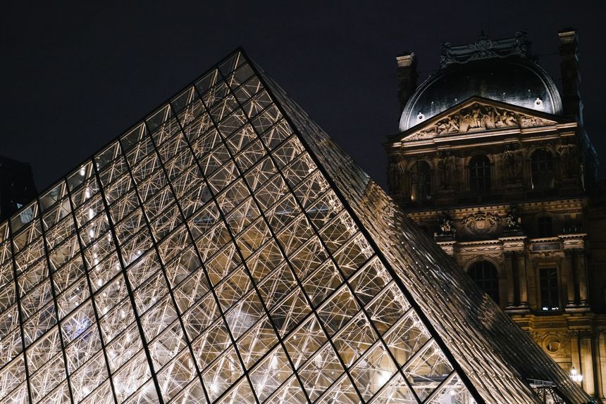 Paris, France – February 15, 2020: Night view of the Louvre Pyramid and the historic Louvre Palace in Paris, France, illuminated with lights.