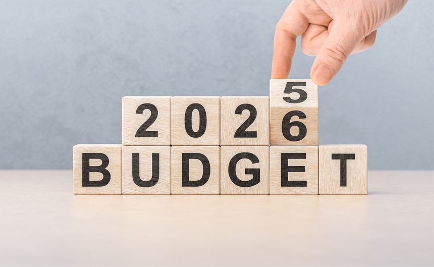 Man completes 2026 number above the word BUDGET. Symbolizes financial goals, annual economic planning, and new year corporate investment