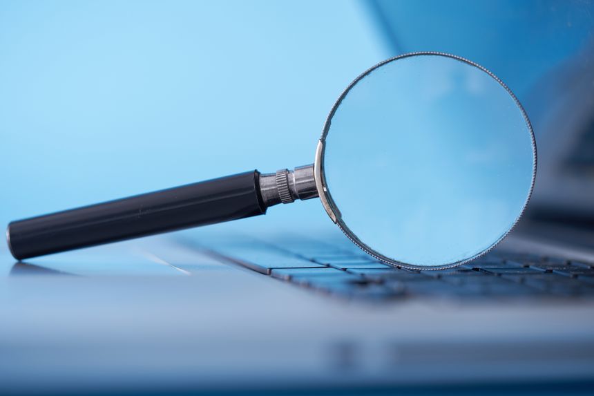 magnifying glass resting on the laptop keyboard