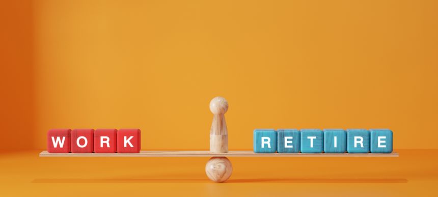 Balancing work and retirement concept with red and blue wooden blocks spelling WORK and RETIRE on a seesaw. Life planning, career transition, and financial future.