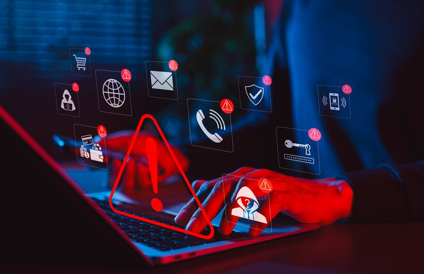 Online scam alert and cybersecurity warning concept. Man holding phone while using laptop, warning sign for scam with icons online threats, phishing, cyber secure, unknown person, suspicious scammer,