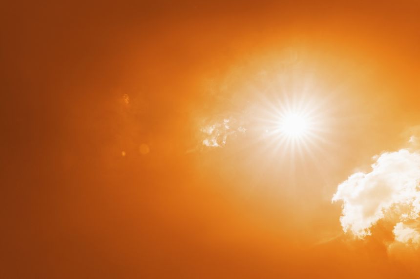 Radiant sun in an orange sky on a hot summer day