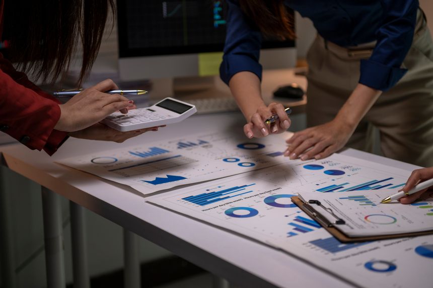 Business team collaborating, analyzing financial data and marketing charts on a desk