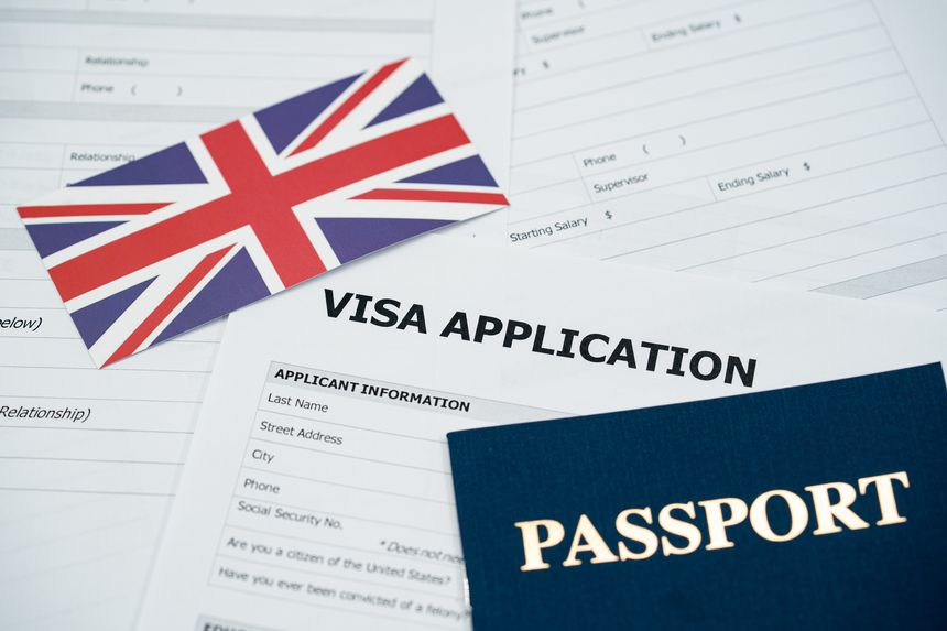 View of United Kingdom visa application form with passport and national flag.