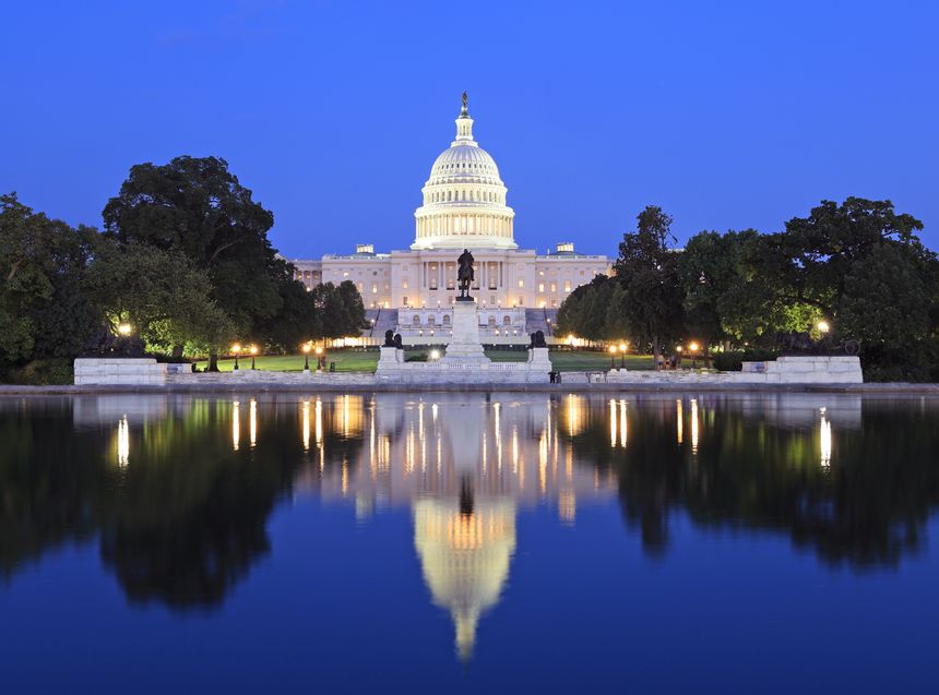 US Capitol illuminated at dusk in Washington DC with nice reflections into the water, USA