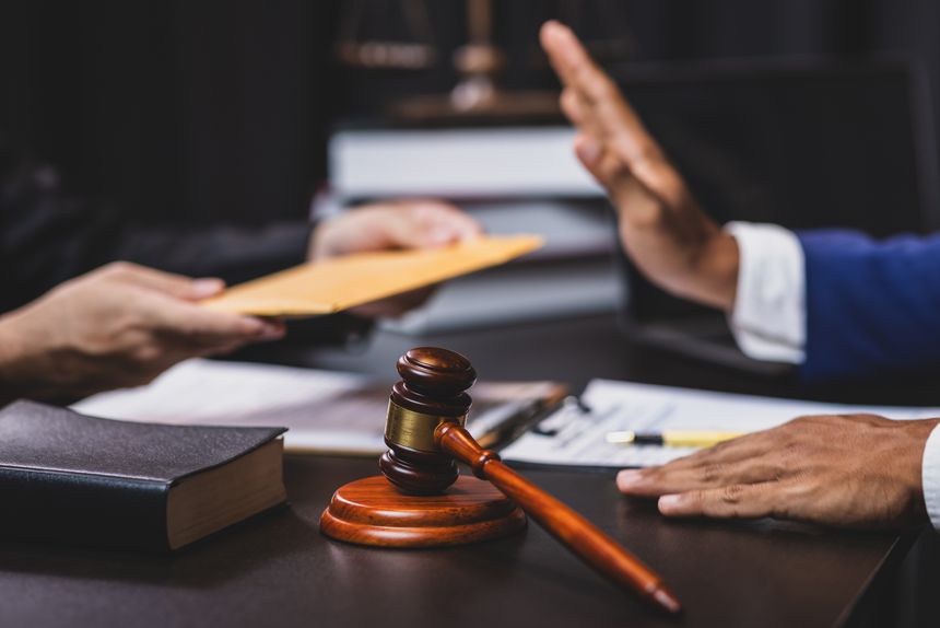 Honest officials refuse bribes. Lawyer refusing a bribe from a businessman in his office, he is pushing back the envelope with his hand.