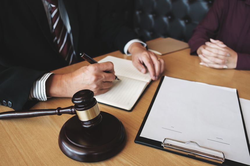 Labor law concept. Lawyer signing legal document with Judges gavel