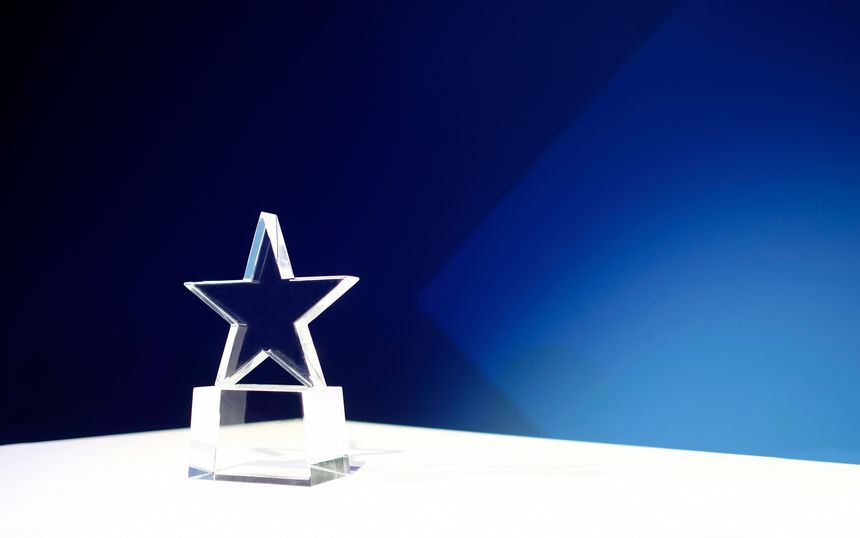 Star-shaped award on a table with spotlights and copy space