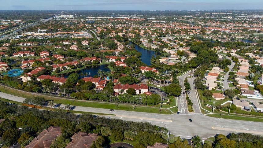 Drone shot of Florida residential area with road and green trees