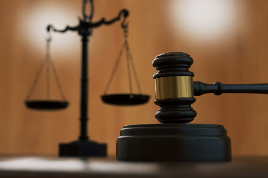 Wooden judge gavel with blurred scales of justice in background. Symbol of law, fairness, and legal system. Professional composition for courtroom, legislation, and judicial authority concepts. Law