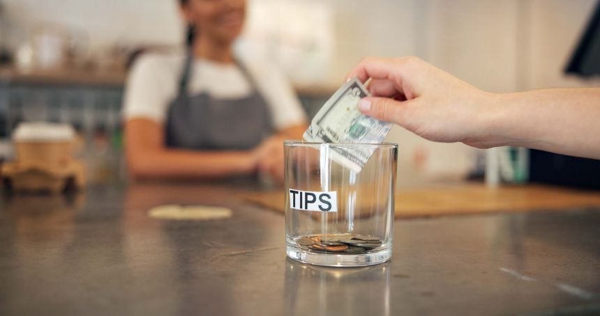 Person, hands and bills with tips at cafe for service excellence, gratitude or kind gesture on countertop. Closeup, shopper or customer with dollar, money or cash in glass for payment or contribution