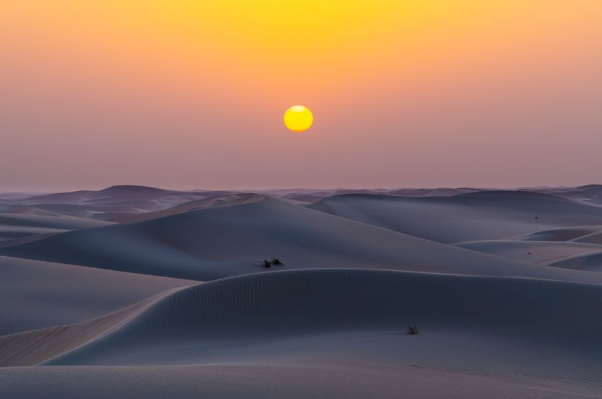 Beautiful sunset-to-sunrise  over a desert sand dune. Vibrant sky transitions, golden light on sand dunes in a remote wilderness location.