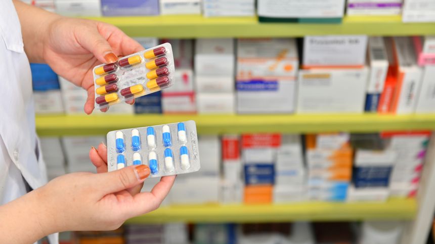 Pharmacist holding medicine capsule pack at the pharmacy drugstore